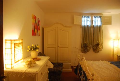 a bedroom with a bed and a table and a window at Villa Talciona in Poggibonsi