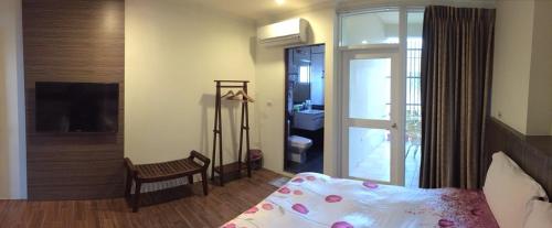 a bedroom with a bed and a sliding glass door at Kenting Lian Nan Wan in Nanwan