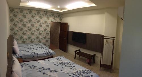 a bedroom with two beds and a flat screen tv at Kenting Lian Nan Wan in Nanwan