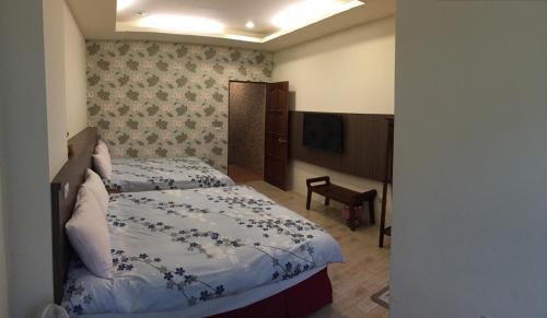 a hotel room with a bed and a television at Kenting Lian Nan Wan in Nanwan