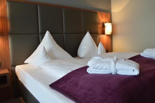 a hotel room with two beds with towels on them at Sante Royale Hotel- & Gesundheitsresort Bad Langensalza in Bad Langensalza