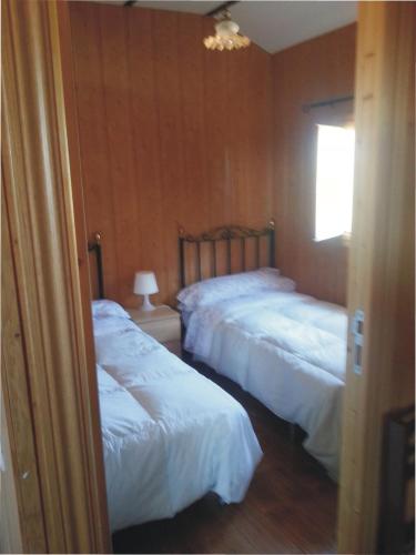 a bedroom with two beds with white sheets and a window at Bungalow Perotonar Ideal Para Familia Con Niños in La Puebla de Cazalla