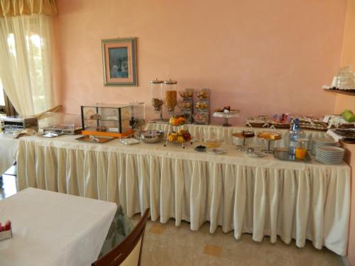 a long white table with food on it at Hotel Le Palme in Gioia Tauro