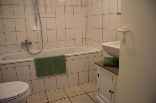 a bathroom with a tub and a toilet and a sink at Apartment-Koeln-Bonn, Ihr Zuhause auf Zeit. in Wesseling