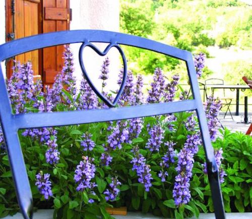 a blue bench in front of purple flowers at Helicon Muses Friendly Mountain B&B Guesthouse in Evangelístria