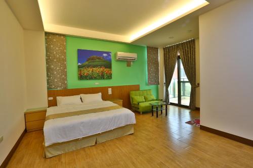 een slaapkamer met een bed en een groene muur bij Chang Cheng Min Su in Magong