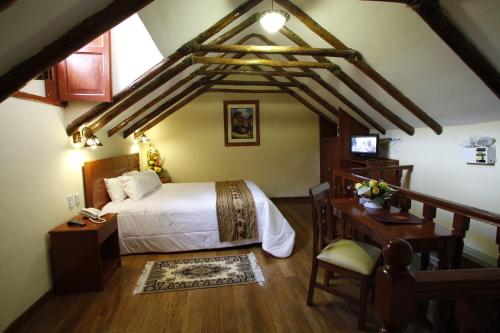 1 dormitorio con cama blanca, escritorio y escritorio en Siete Ventanas en Cuzco