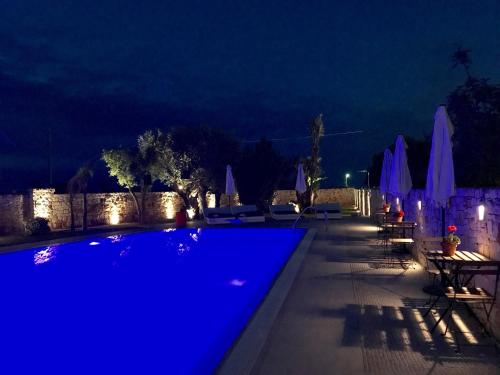 a swimming pool at night with blue lighting at Carone Suite-Charme&Pool by Bluette in Polignano a Mare