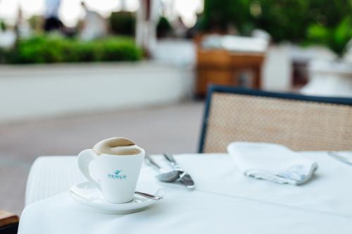 a cup of coffee sitting on top of a table at Hotel Perla in Herceg-Novi