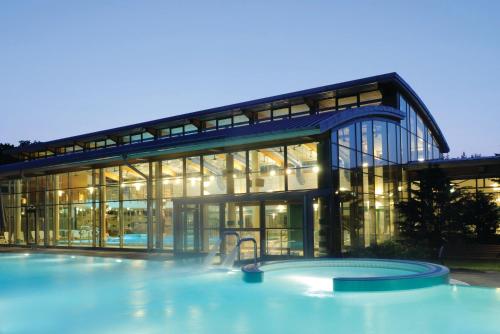 a building with a swimming pool in front of it at Sante Royale Hotel- & Gesundheitsresort Bad Langensalza in Bad Langensalza