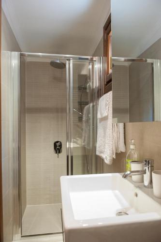 a bathroom with a shower with a sink and a white sink at Naftilos Villa Sani with private Pool in Sani Beach