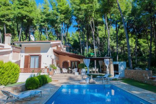 a house with a swimming pool in the yard at Naftilos Villa Sani in Sani Beach