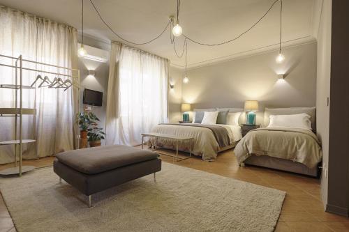 a bedroom with two beds and a ottoman at B&B Palazzo Bibirria in Agrigento