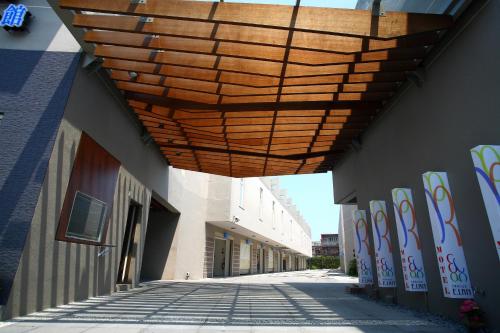 ein Holzdach über einer Straße mit einem Gebäude in der Unterkunft Elan-Motel in Wujie