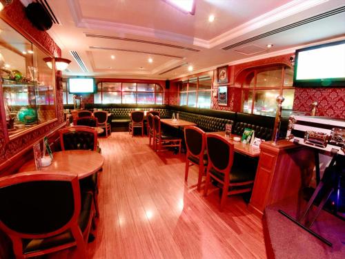 a restaurant with wooden tables and chairs and a television at Arabian Courtyard Hotel & Spa in Dubai