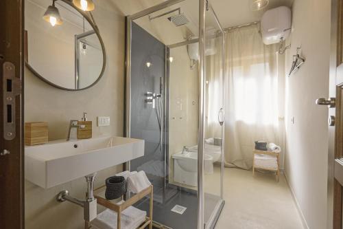 La salle de bains est pourvue d'un lavabo et d'une douche avec un miroir. dans l'établissement B&B Palazzo Bibirria, à Agrigente