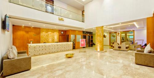 a lobby with couches and chairs and a reception desk at RG Hotels and Resort in Mālūr