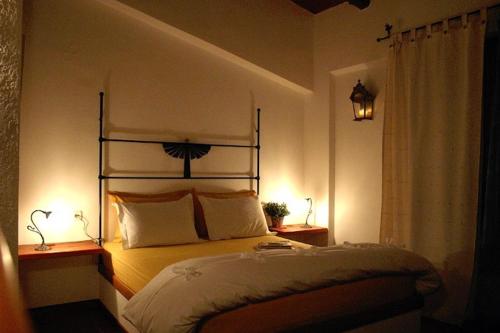 a bedroom with a bed with two lamps on two tables at Helicon Muses Friendly Mountain B&B Guesthouse in Evangelístria