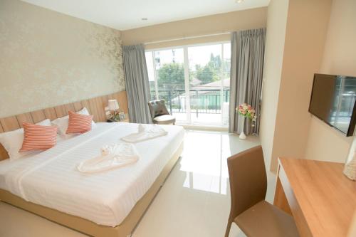 a bedroom with a bed with a television and a window at The Bedroom Ladprao 101 Bangkok - SHA in Bangkok
