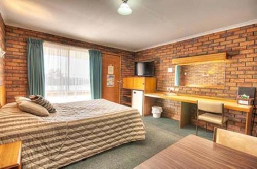 Un pat sau paturi într-o cameră la Golden Palms Motel