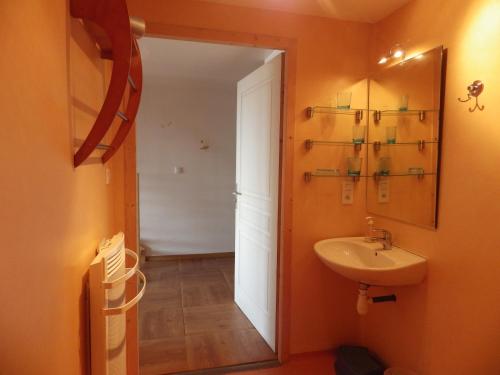 an orange bathroom with a sink and a mirror at gites Les Bleuets in Vagney