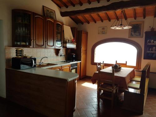 cocina con mesa y cocina con ventana en Affittacamere Adri, en Uzzano