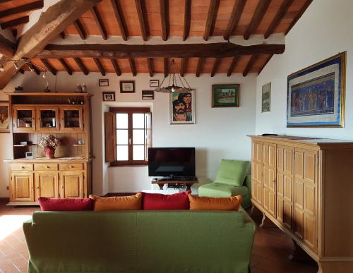 a living room with a green couch and a television at Affittacamere Adri in Uzzano