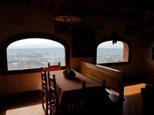 a dining room with two large windows and a table at Affittacamere Adri in Uzzano
