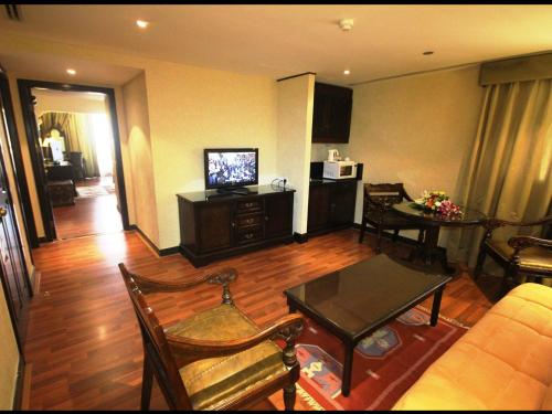 a living room with a couch and a television at Arabian Courtyard Hotel & Spa in Dubai
