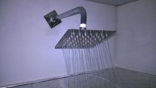 a shower with a shower head attached to a wall at Danara Homestay in Sigiriya