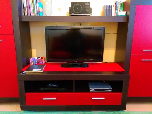 a flat screen tv on a red entertainment center at Dresdner Ferien Apartment in Dresden