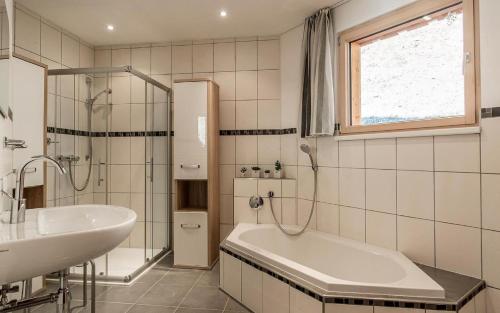 a white bathroom with a tub and a sink at Ferienwohnung Lifinar in Schruns-Tschagguns