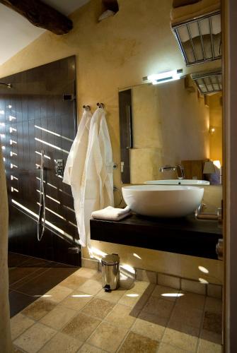une salle de bain avec un lavabo et un grand miroir dans l'établissement Hameau de Pichovet, à Vachères