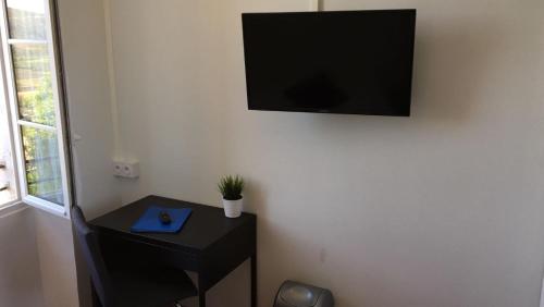 een flatscreen-tv aan een muur bij Hotel Belvue in Sault-de-Vaucluse