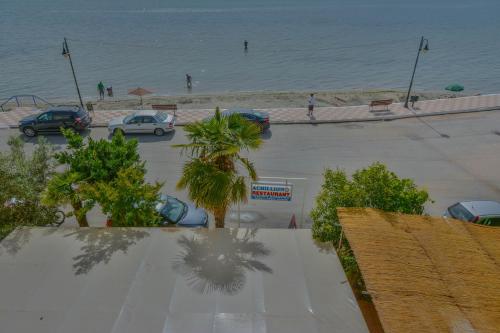 a parking lot next to the beach with cars parked at Hotel Achillion in Makrýgialos