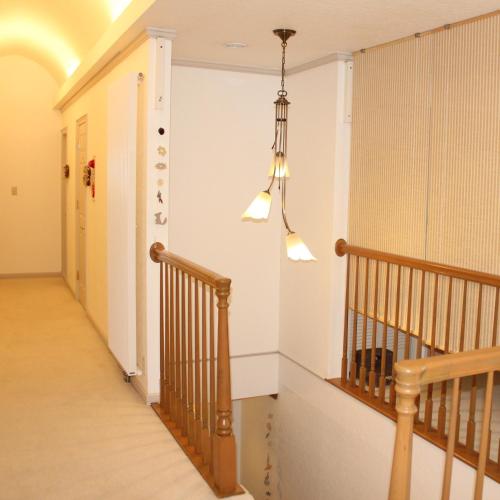 a hallway with a staircase and a chandelier at Rusutsu Pension Clydesdale in Rusutsu