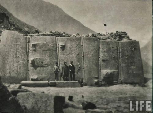 an old photo of two men standing in front of a building at Peru Quechua's Lodge Ollantaytambo in Ollantaytambo