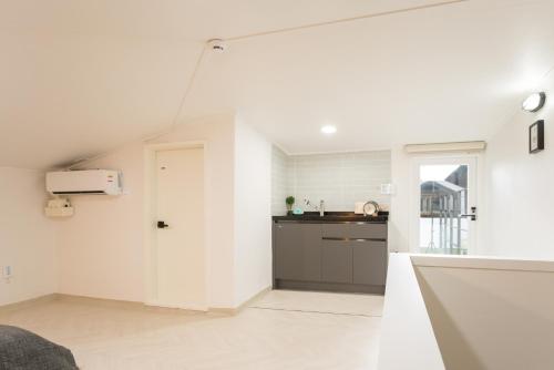 a kitchen with white walls and a door in a room at Neat House in Seoul