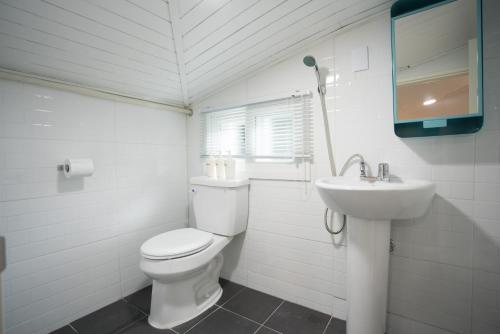 a white bathroom with a toilet and a sink at Neat House in Seoul