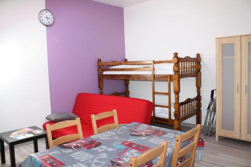 una sala da pranzo con tavolo e letto a castello di L'oiseau bleu a Salin-de-Giraud