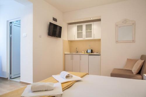a small room with a bed and a kitchen at Apartments & Rooms Jelka in Kotor