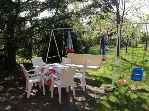 a patio with a table and chairs and a swing at Maslina Rooms in Smederevo