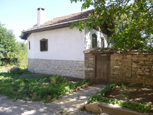 ein altes Steinhaus mit einem Tor und einer Steinmauer in der Unterkunft Tanya's House in Kŭrpachevo