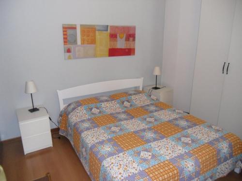 ein Schlafzimmer mit einem Bett mit einer Decke darauf in der Unterkunft Garda Blu Apartment in Riva del Garda