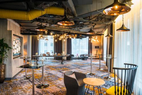 a lobby with tables and chairs and windows at Novotel London Canary Wharf in London