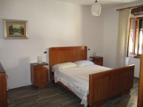 a bedroom with a bed with a wooden headboard at Casa Porto Azzurro in Porto Azzurro
