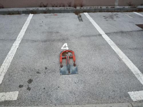 een lege parkeerplaats met een oranje voorwerp op de grond bij Anita Medulin Apartment in Medulin