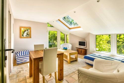 a living room with a table and a bedroom at Maison des Bois in Bièvres