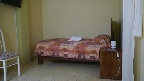 a bedroom with a bed and a table and a chair at El Parque Hotel in Andahuaylas