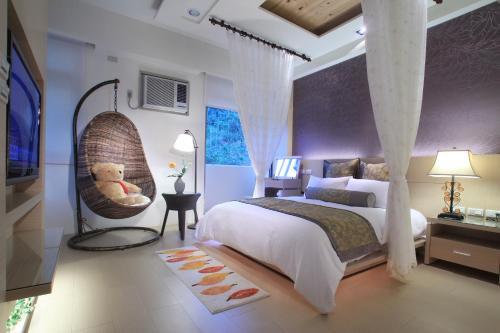 - une chambre dotée d'un grand lit avec un ours en peluche sur une balançoire dans l'établissement Cha Guo Zi, à Datong